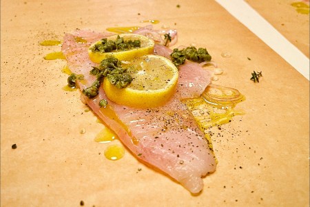 Coked fish on paper with lemon slices