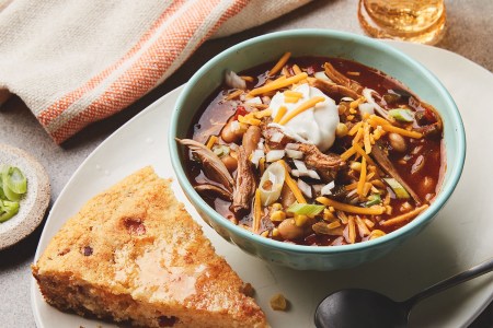 bowl with chili and piece of cornbread on a plate