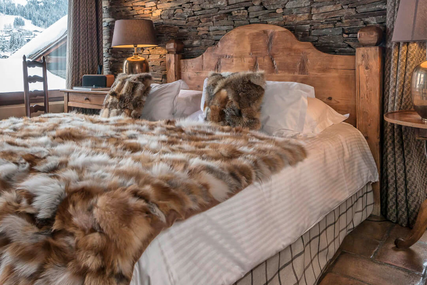 Room in a cabin with bed and furry blanket and pillows