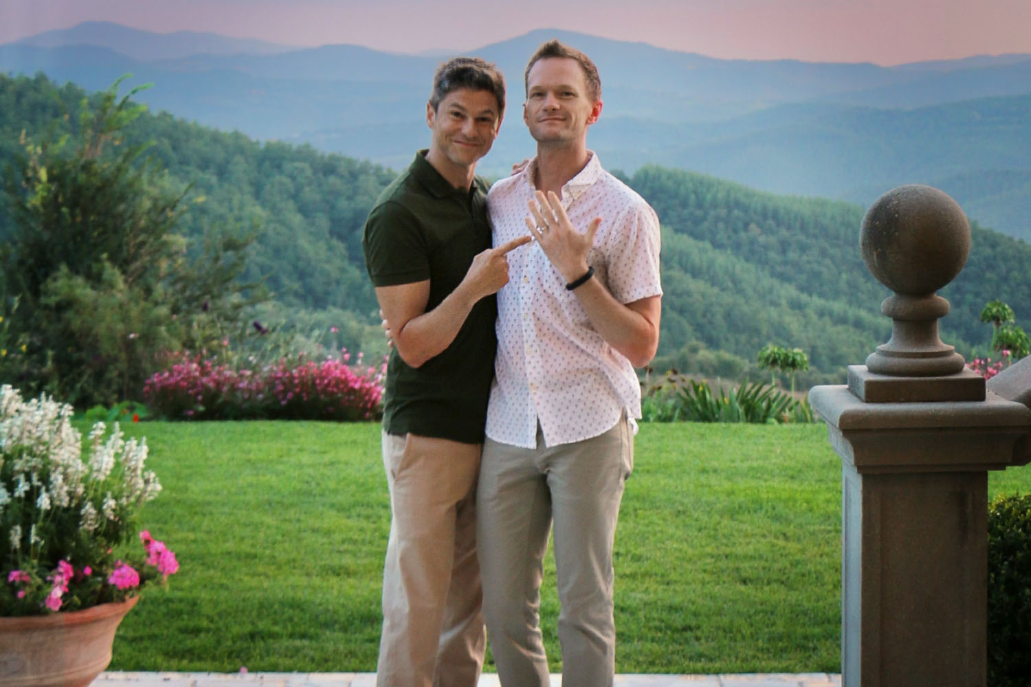 Neil Patrick Harris and David Burtka standing next to each other in front of a landscape