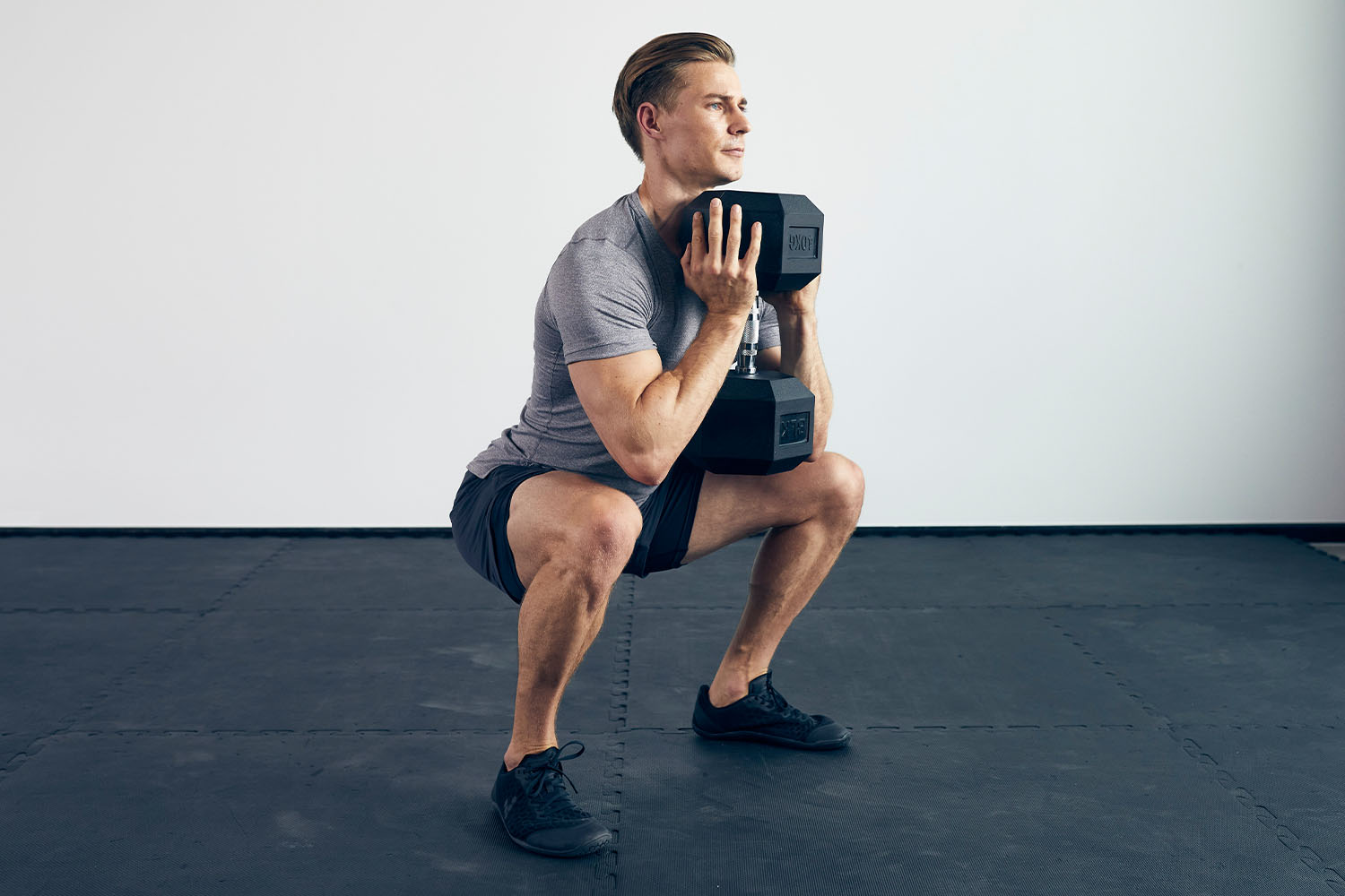 Jack Hanrahan, personal trainer, squatting and holding a dumbell with both hands