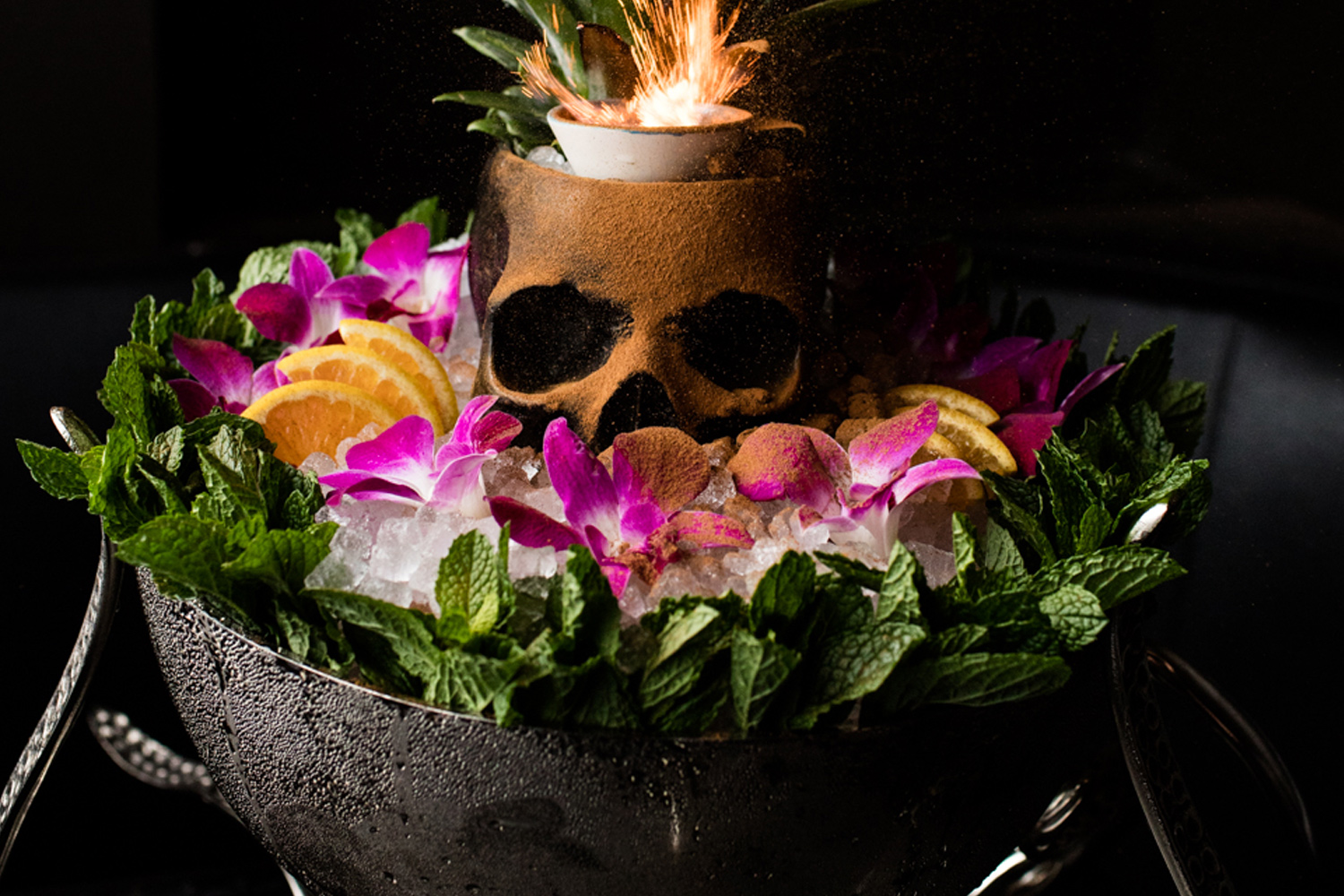 Skeleton decorated drink with orchid flowers in bowl