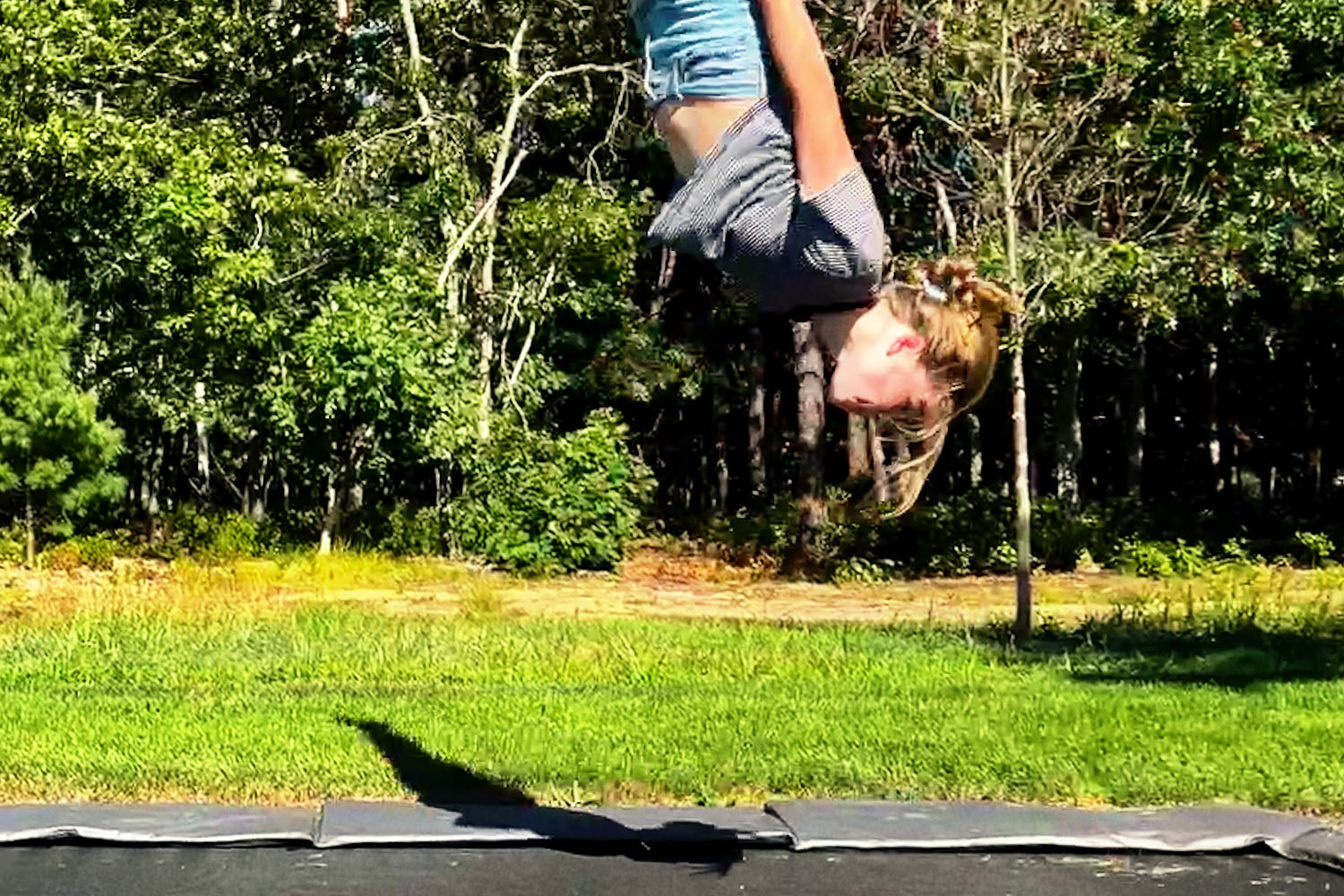 inverted girl jumping on a trampoline