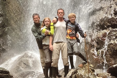 Family standing in front of waterfall