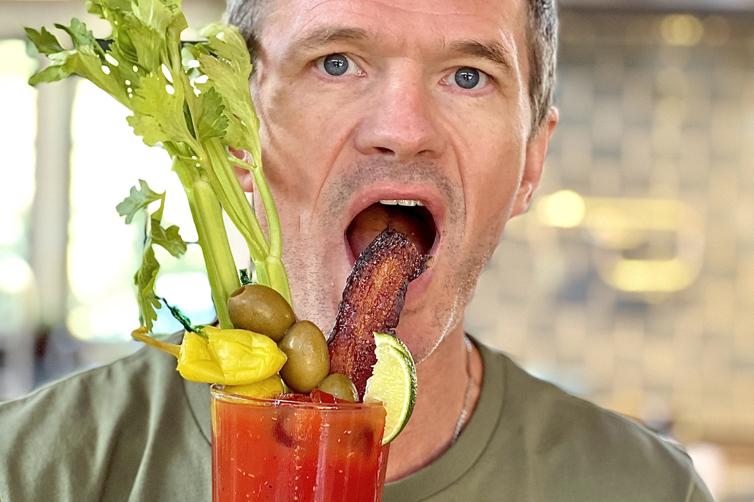 Man with bloody mary drink and bacon relish
