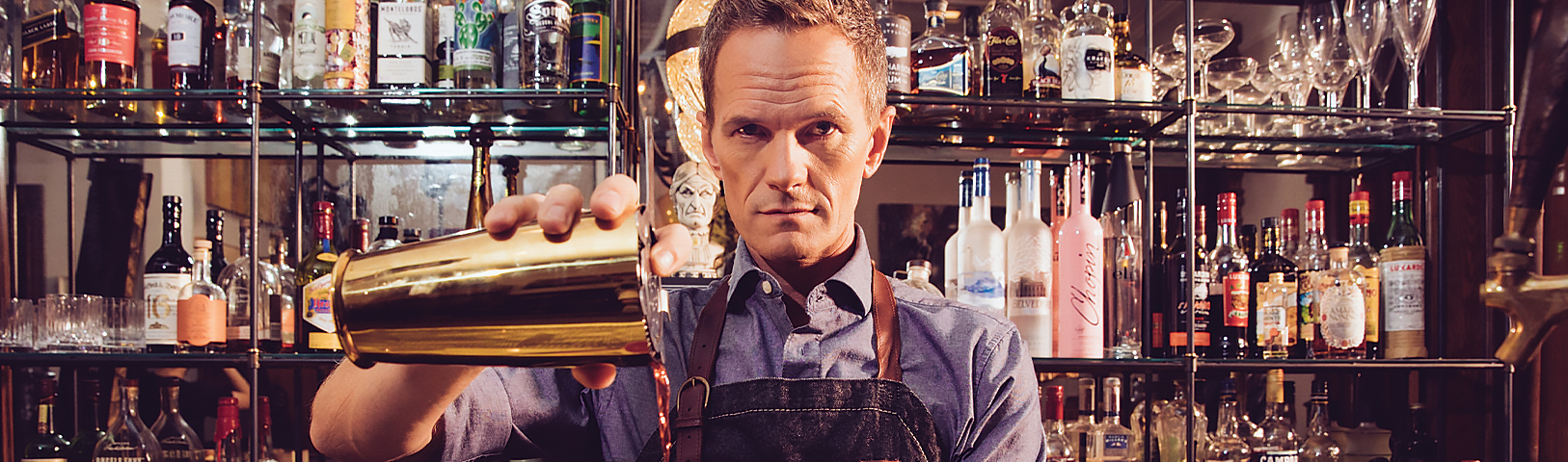Neil Patrick Harris pouring drinks at a bar