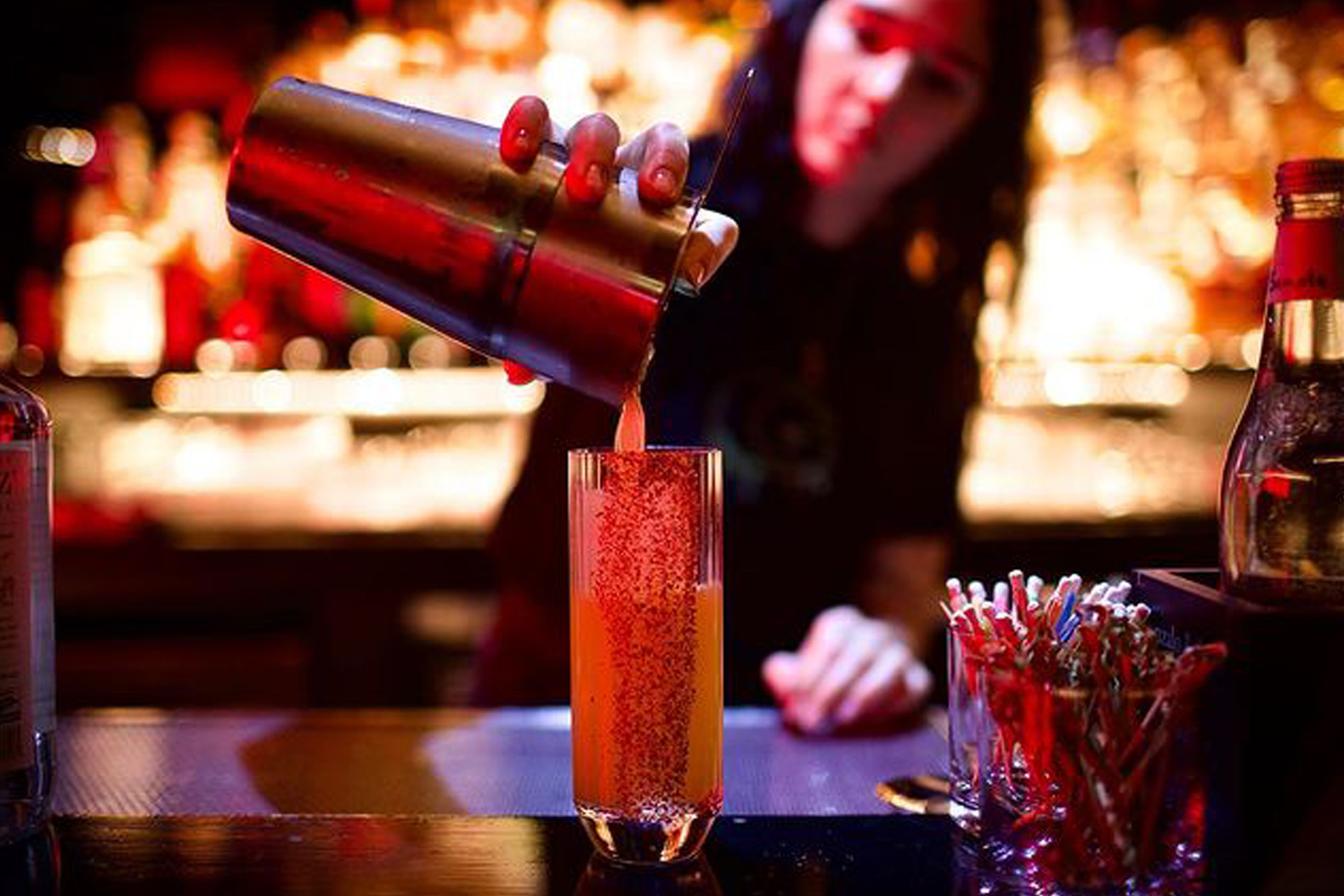 Woman pouring drink at Nothing Really Matters bar in New York City