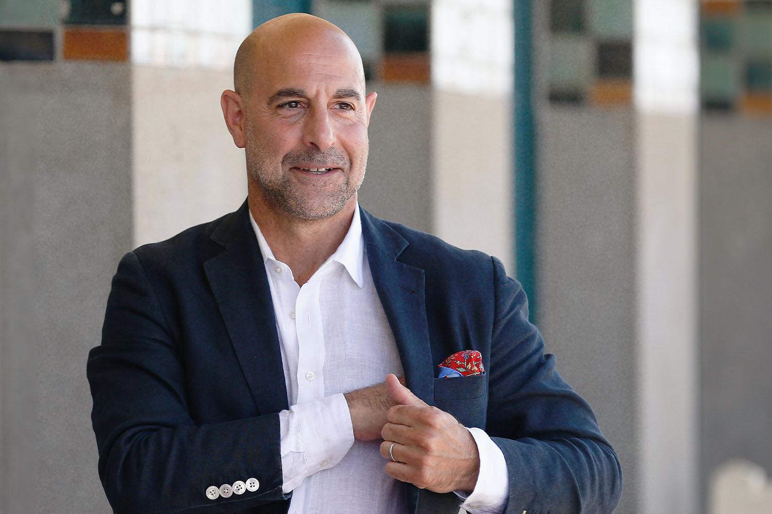 Stanley Tucci posing in a suit.