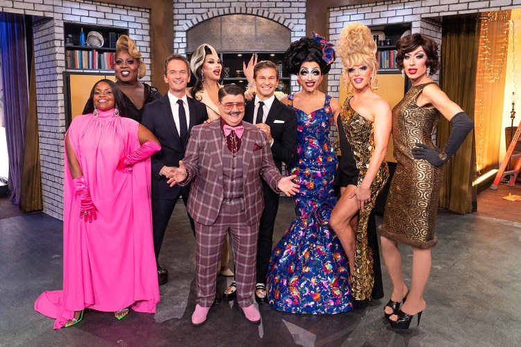 Drag queens and kings standing on a tv set