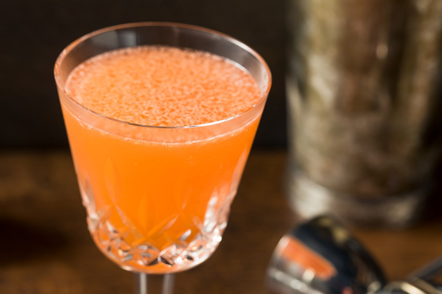 orange cocktail on bar counter with dark background