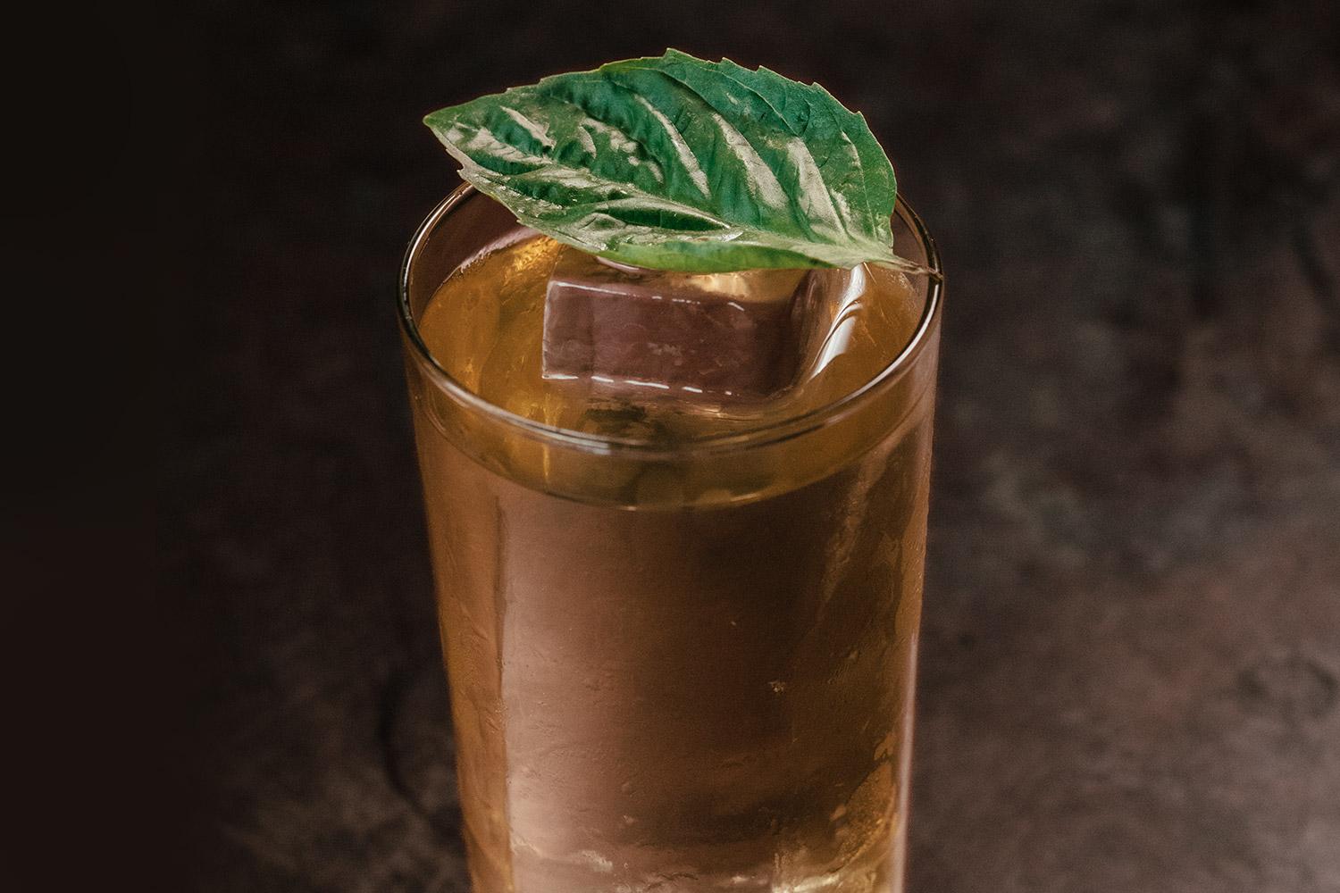 Gazpacho with basil leaf on dark background