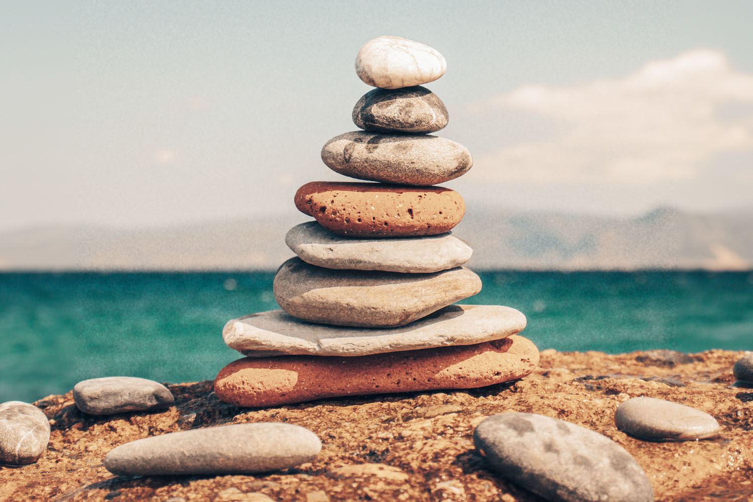 rocks piled on top of each other in front of the ocean.