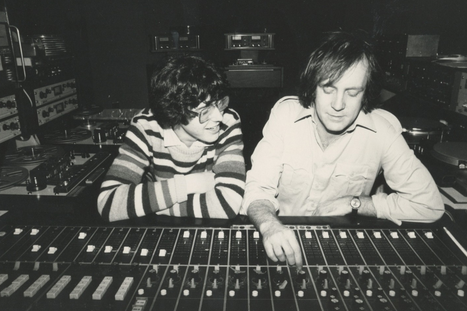Sepia photo of Ira Glass and his mentor Keith Talbot in NPR’s old studios circa 1980