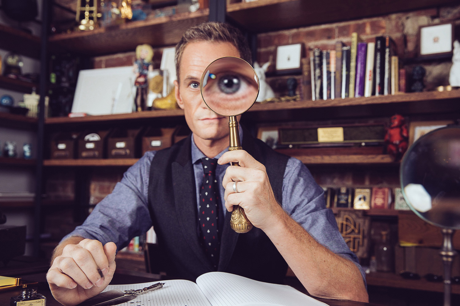 Neil Patrick Harris with magnifying glass in library