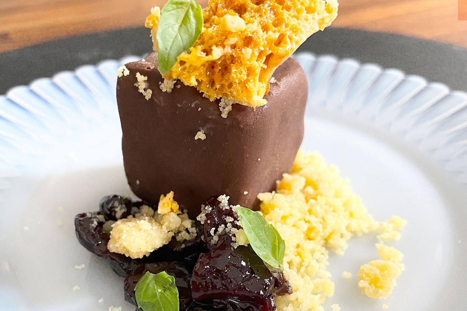 Ice cream sundae with chocolate hard shell, basil, honeycomb and corn soil