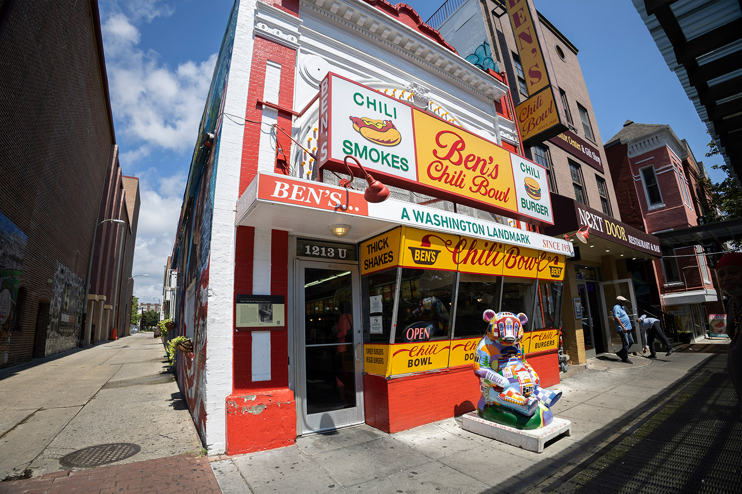Outside of Ben's Chili Bowl brick restaurant painted bright red, yellow and white