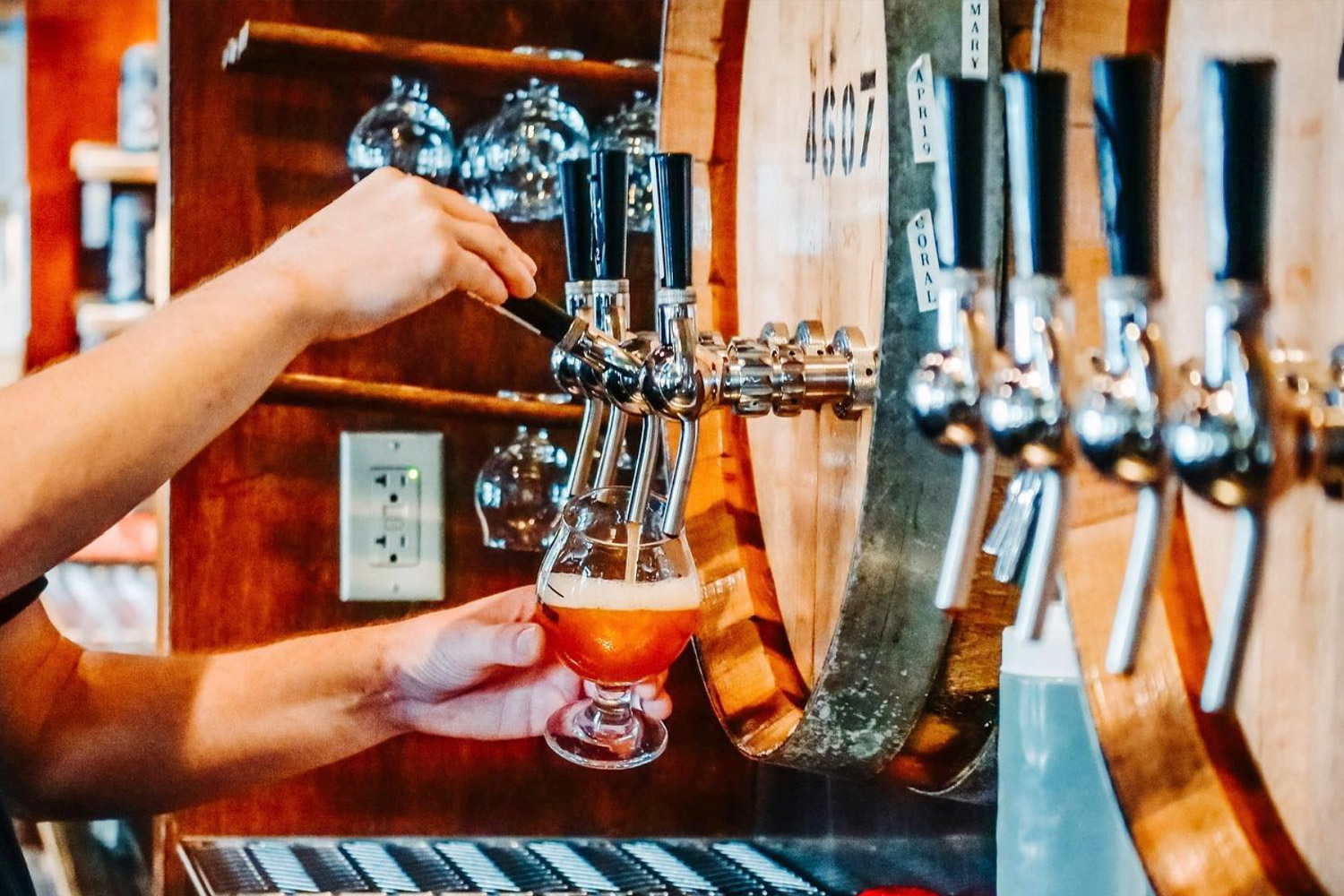 Pouring beer from a tap into snifter glass