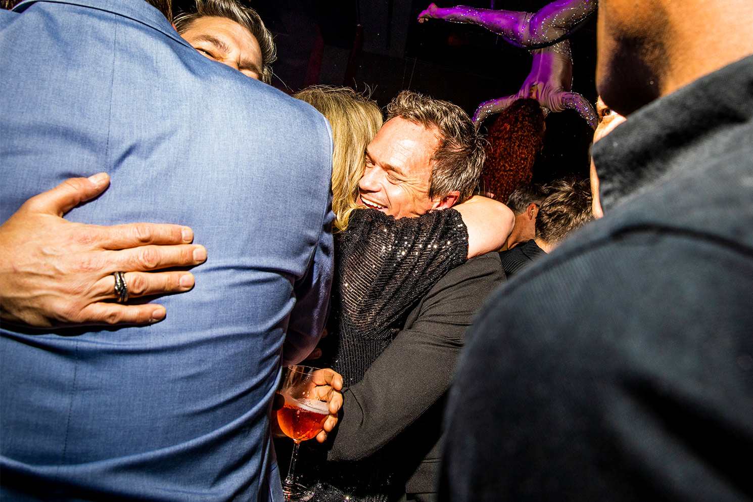 Neil Patrick Harris hugging friend and smiling in group at his 50th birthday party