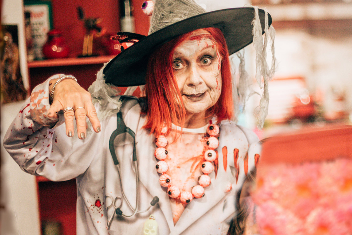 Older woman dressed up for Halloween standing in kitchen