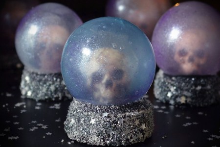 Opaque and shimmery purple and blue sugar globes with a skull inside and a sparkly, silver sprinkle base