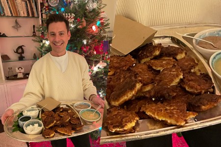 Man holding tray full of latkes and sauces on the side