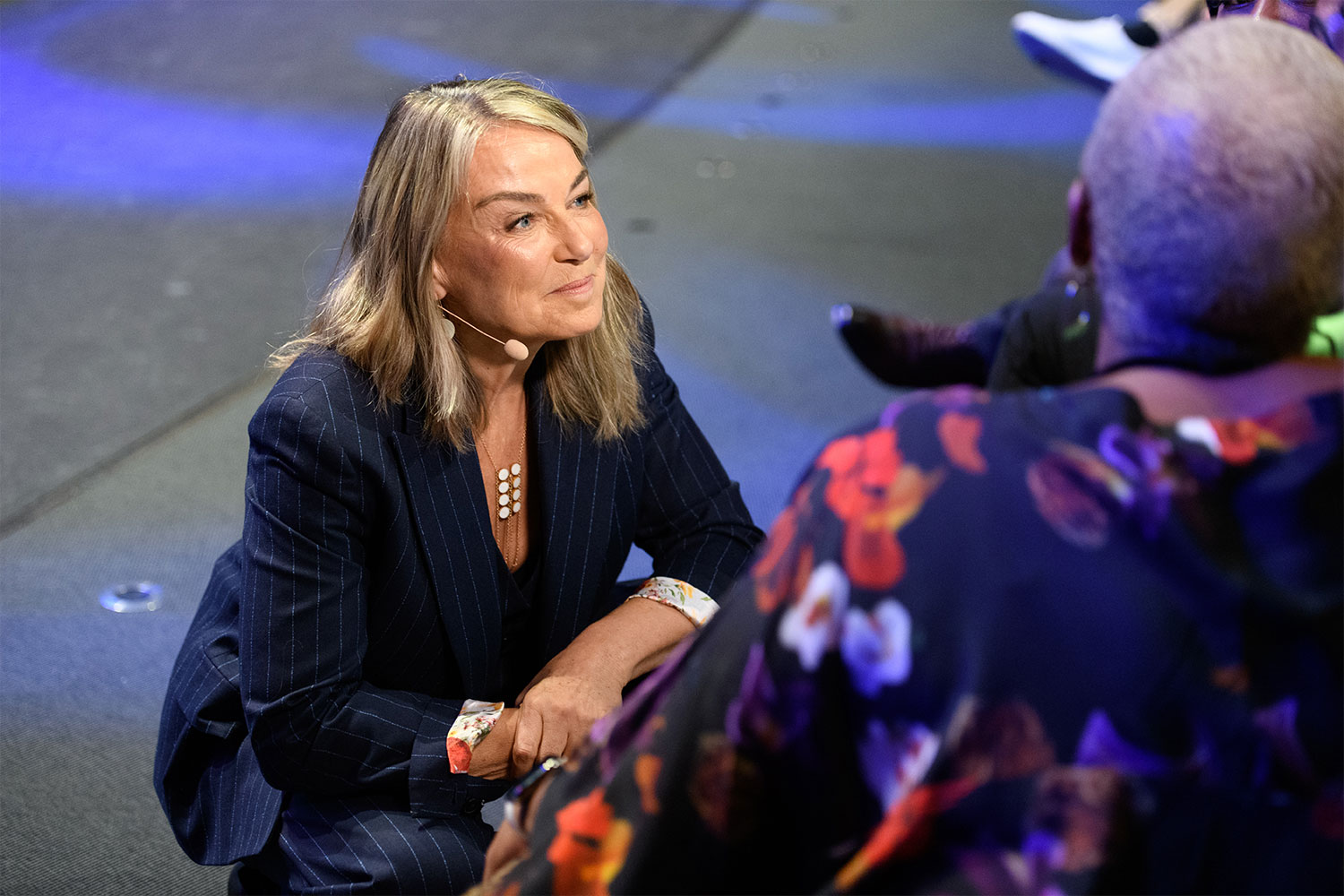 Esther Perel stand kneels down to speak to front row audience