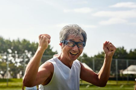 A man with goggles screaming with joy in a guts pose playing soccer