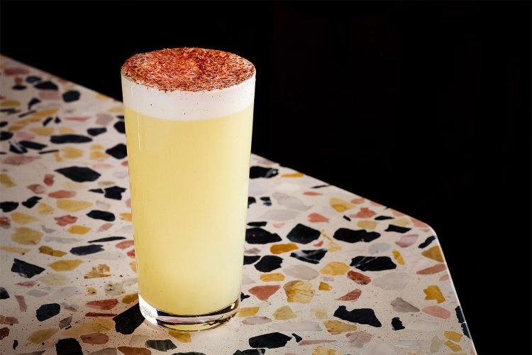 Yellow drink with foam and spices on top