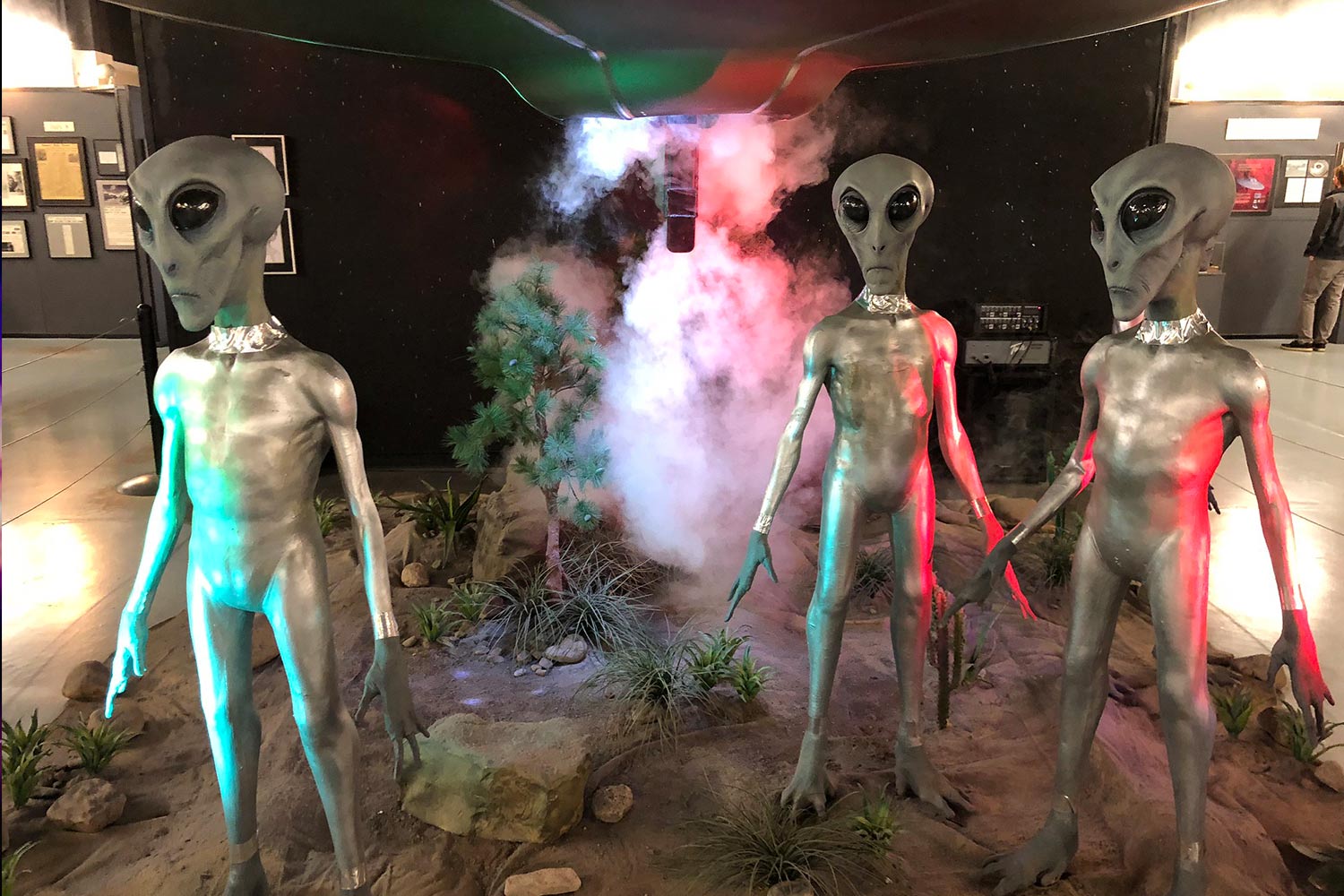 Exhibit of alien statues with smoke behind